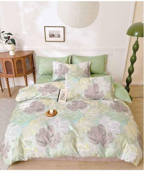 A king size fitted bedsheets set with pillow covers featuring a floral pattern in a gray color, displayed on a bed in a furnished room.